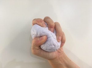 Hand squeezing a brain.